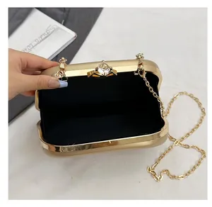 Macro view of gold evening clutch featuring a crystal planet clasp and black lining