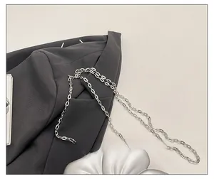 Detail of silver metal flower bag with fine chain strap and glossy petal texture