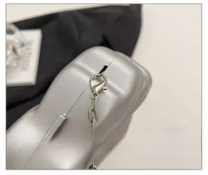 Macro shot of silver metal lobster clasp and chain link hardware on the handbag