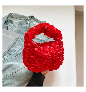 Macro shot of red pleated satin handbag with cloud-like texture and soft ruffles