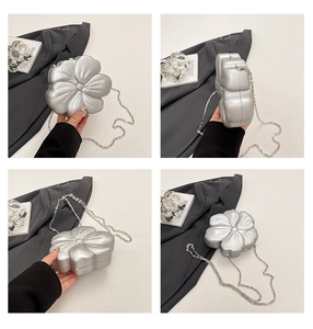 Detail view of silver floral acrylic clutch with chain strap and 3D petal structure