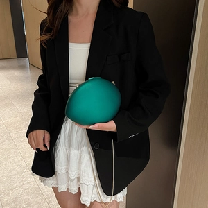 Modern oval acrylic clutch bag in dark green with golden chain strap for evening wear