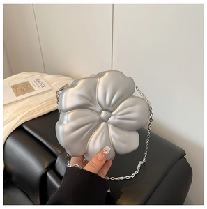Detail of silver flower-shaped acrylic hard shell mini bag with pearlized finish and chain