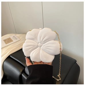 Detailed texture of white flower-shaped crossbody bag with gold metal chain strap