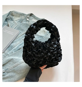 Detail view of black pleated satin cloud bag with soft fabric ruffles and hobo handle