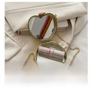 Macro shot of the heart-shaped gold lipstick case interior featuring dual mirrors