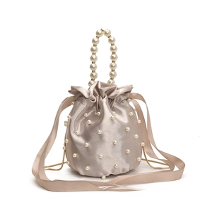 Elegant champagne satin drawstring bucket bag with pearl embellishments and a top handle