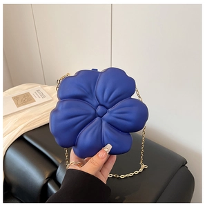 Detailed macro view of the 3D blue flower-shaped crossbody bag with a slim gold chain