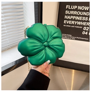 Detail view of green flower-shaped mini acrylic bag with fine gold chain strap