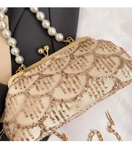 Dettaglio della borsa da sera con paillettes champagne, manico di perle e chiusura
