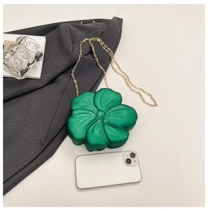 Mini green flower acrylic crossbody bag with gold chain strap shown next to a smartphone