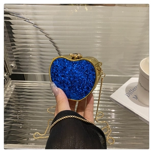 Close-up of heart-shaped blue sequin evening bag with gold metal frame and chain