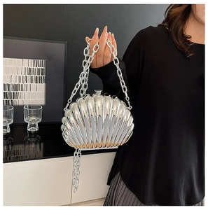 Close-up of silver shell clutch bag with metallic texture and thick chain strap detail