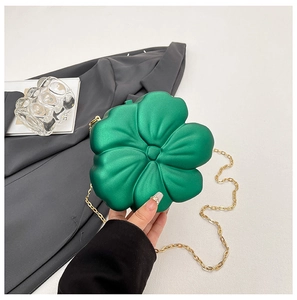 Macro view of green flower-shaped mini bag with matte texture and gold chain link