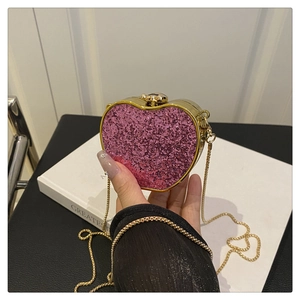 Detailed close-up of pink heart-shaped sequin mini bag with gold chain strap
