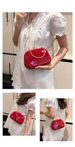 Red patent leather evening clutch bag with gold handle and chain strap detail