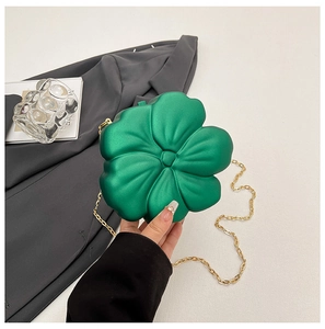 Detail view of a green 3D flower-shaped mini bag featuring a gold metal chain strap