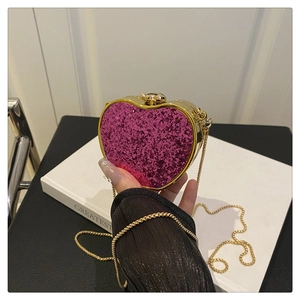 Close-up of heart-shaped glitter evening bag with gold metal frame and chain