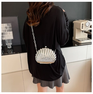 Detailed close-up of shell-shaped silver handbag with metallic texture and chain strap