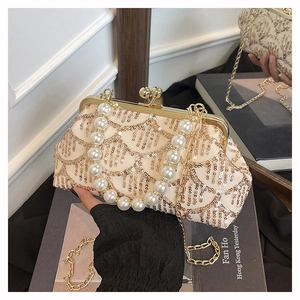 Dettaglio del ricamo in paillettes dorate e manico di perle su borsa da sera vintage