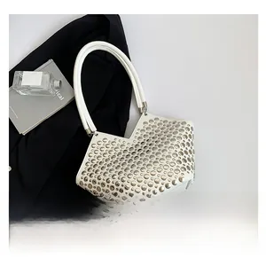 Détails du sac blanc avec rivets argentés et anse haute au style punk chic et moderne