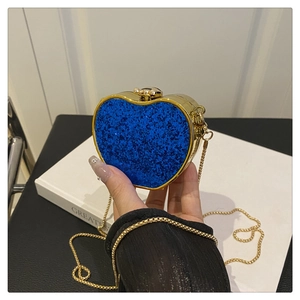 Close-up of royal blue sequin heart-shaped mini bag with gold chain and spherical clasp