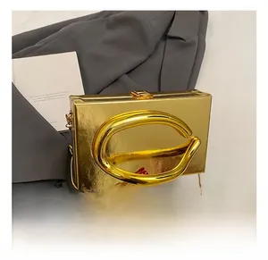 Detail of gold acrylic clutch featuring a large oval metal handle and chain strap