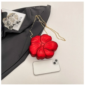 Macro detail of red 3D flower acrylic mini bag with elegant gold metal chain strap