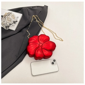 Macro detail of red 3D floral acrylic mini bag with elegant gold chain and matte finish