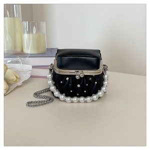 Detail of black pleated mini box bag with pearl handle and rhinestone embellishments