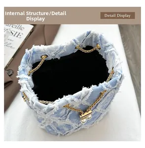 Detail view of denim bucket bag interior with pearl drawstrings and frayed edges