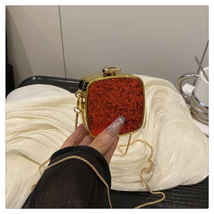 Detail of red glitter acrylic mini square clutch bag with golden metal chain
