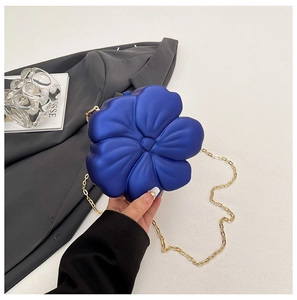 Detail of blue matte floral acrylic handbag with gold chain and smooth petal texture