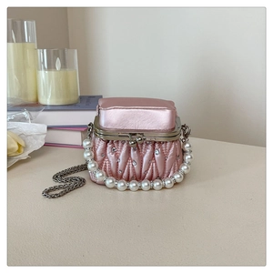 Detail of light pink pleated mini handbag with pearl handle and rhinestone buckle