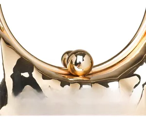 Détail du fermoir à billes dorées et de la poignée ronde du sac de soirée motif craquelé