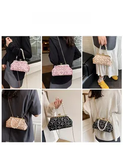 Dettaglio borsa vintage con paillettes e manico di perle con chiusura a cuore in metallo