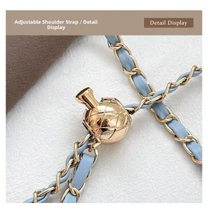 Macro detail of adjustable golden ball slider on light blue leather and metal chain strap