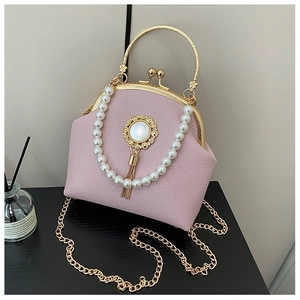 Close-up of pink litchi grain shell bag featuring pearl trim and gold clasp detail