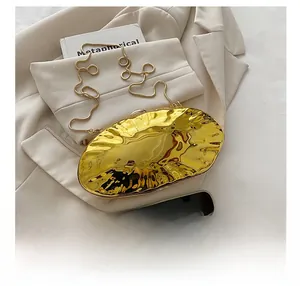 Size comparison of a gold rippled shell evening clutch next to a smartphone device