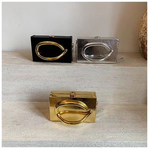 Three acrylic box clutch bags in gold, silver and black with round metal handles