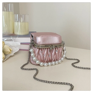 Detail of pink pleated satin mini bag with pearl handle and rhinestone accents