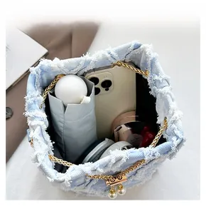Internal view of light blue denim bucket bag showing large capacity for daily items