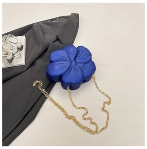 Detailed side view of 3D royal blue flower-shaped crossbody bag with gold chain strap