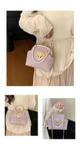 Close-up of lavender shell bag featuring pearl handle and golden heart metal clasp
