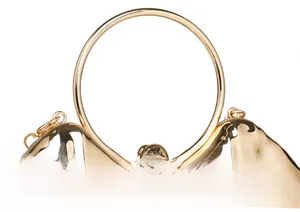 Detail view of the metallic clutch with a round metal handle and textured finish