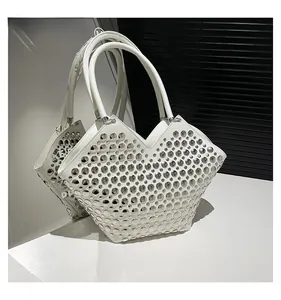 Détail du sac seau blanc avec rivets argentés et découpe design en V élégante