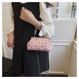 Dettaglio della borsa da sera con paillettes rosa, manico di perle e catena d'oro