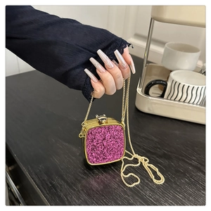 Close-up of pink glitter acrylic mini bag with gold chain strap and metal frame