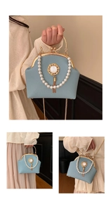 Detail of light blue pearl handbag with gold metal handle and vintage tassel pendant