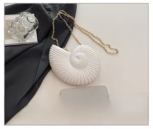 Detailed comparison of white seashell clutch bag size relative to a smartphone